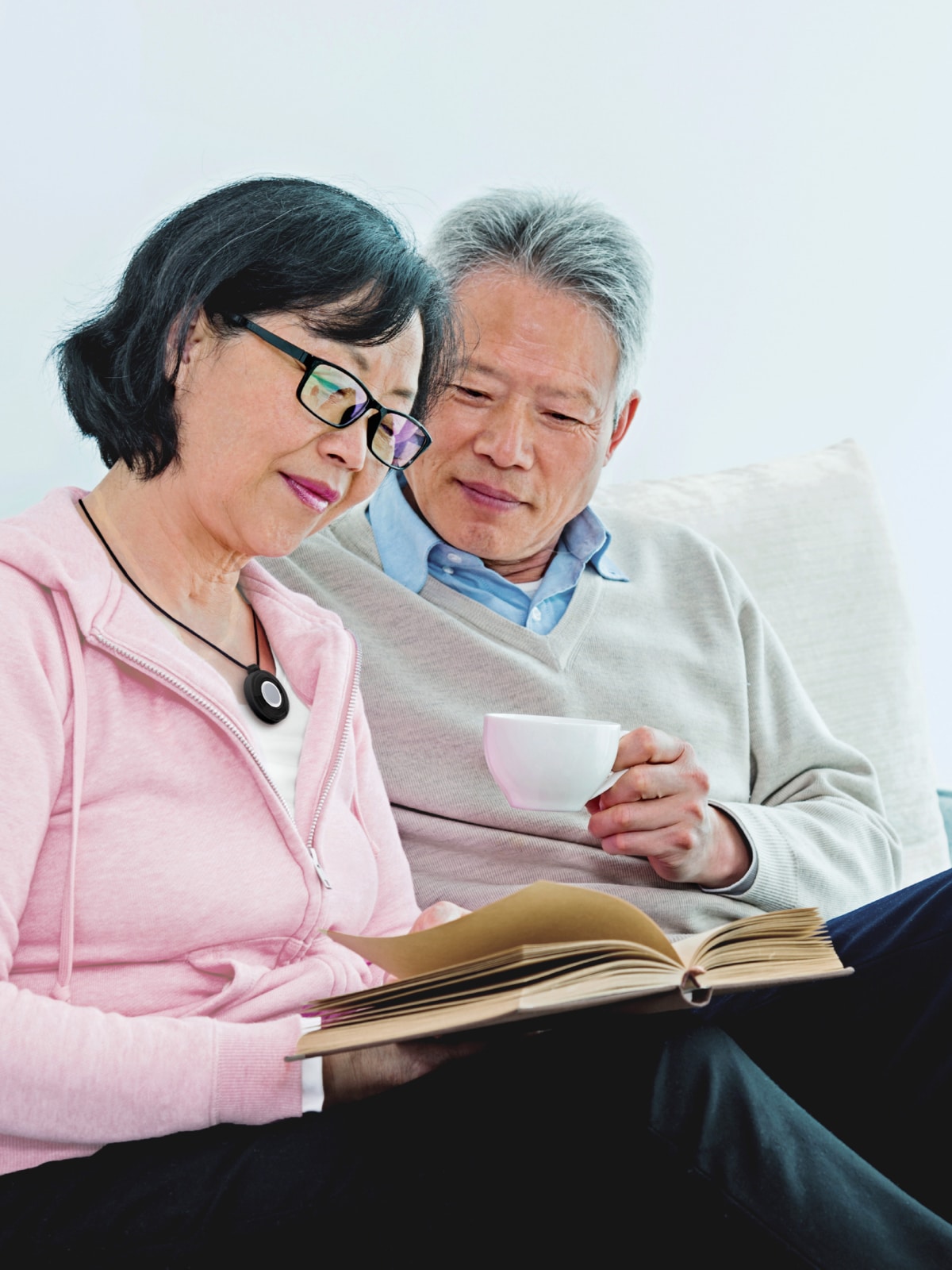 Woman wearing Medical Alert help button reads with husband