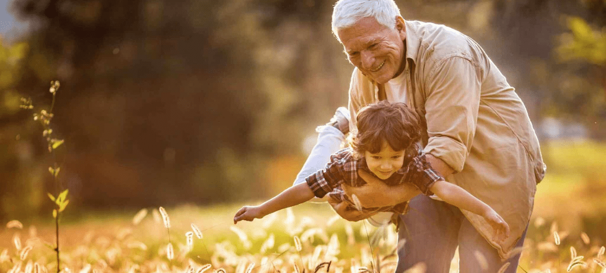 Grandfather & grandson in field